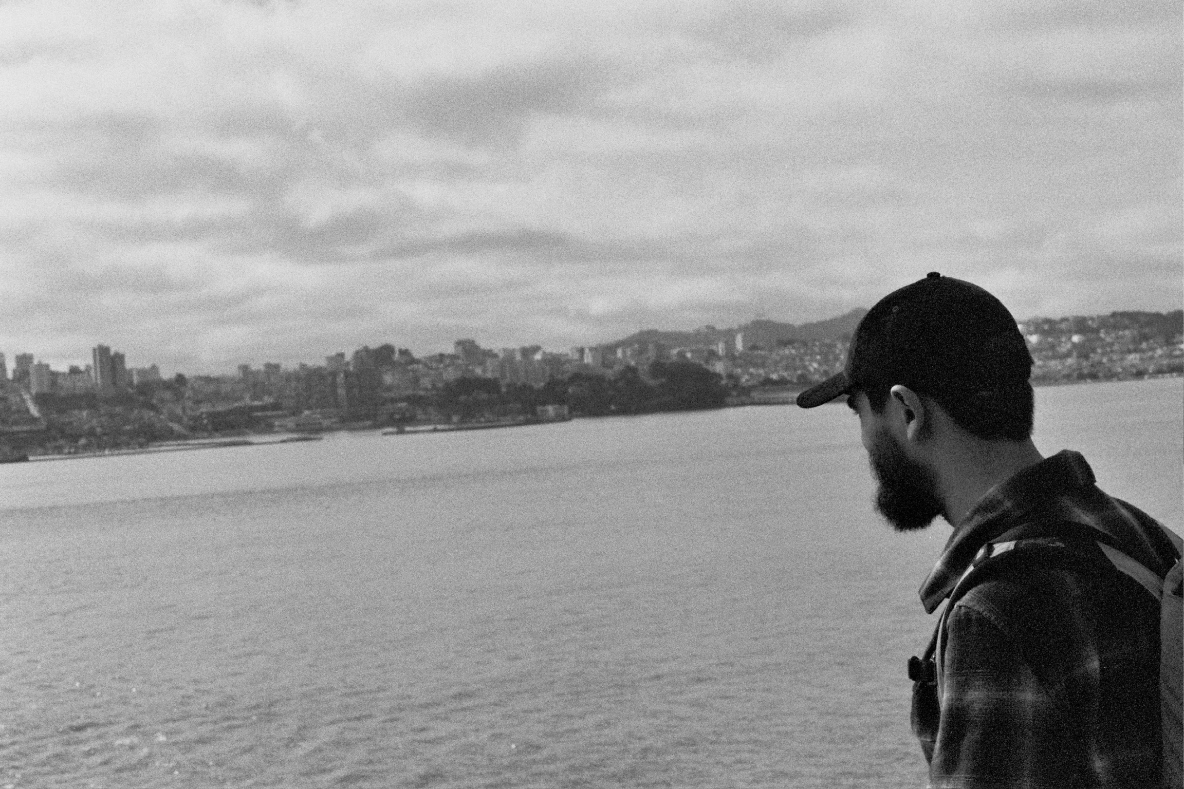 Trevor Cash looking out over the water toward a city skyline